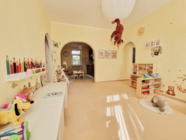 Heller, kinderfreundlicher Raum mit Spielzeug, Zeichnungen und gemütlicher Atmosphäre.